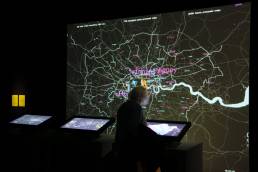 Image of a woman using a touch screen within the London Data Streams installation by Tekja